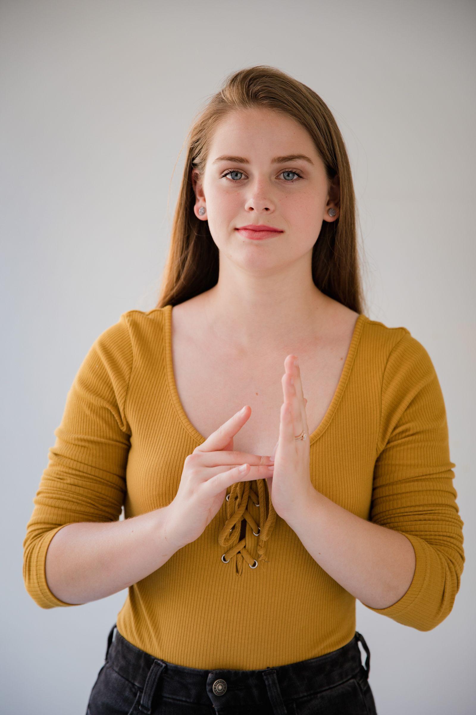 Interpreter signing in American Sign Language with both hands