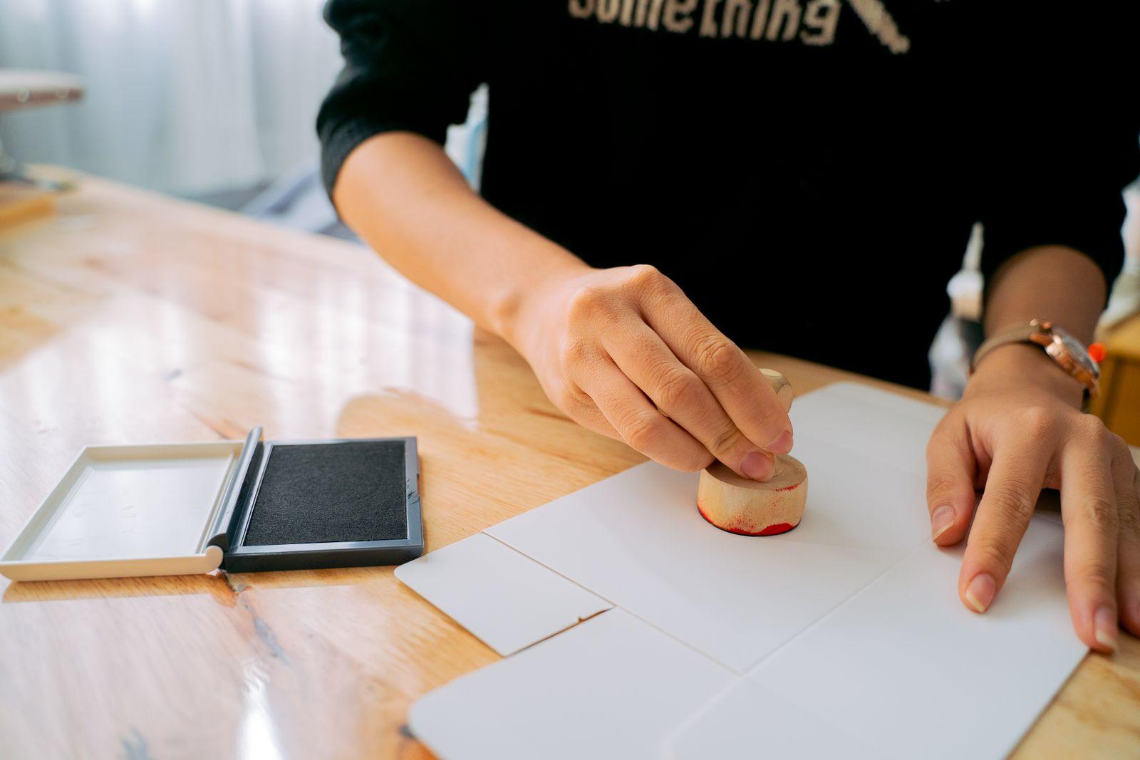 Hands stamping an official certified translation document at a desk