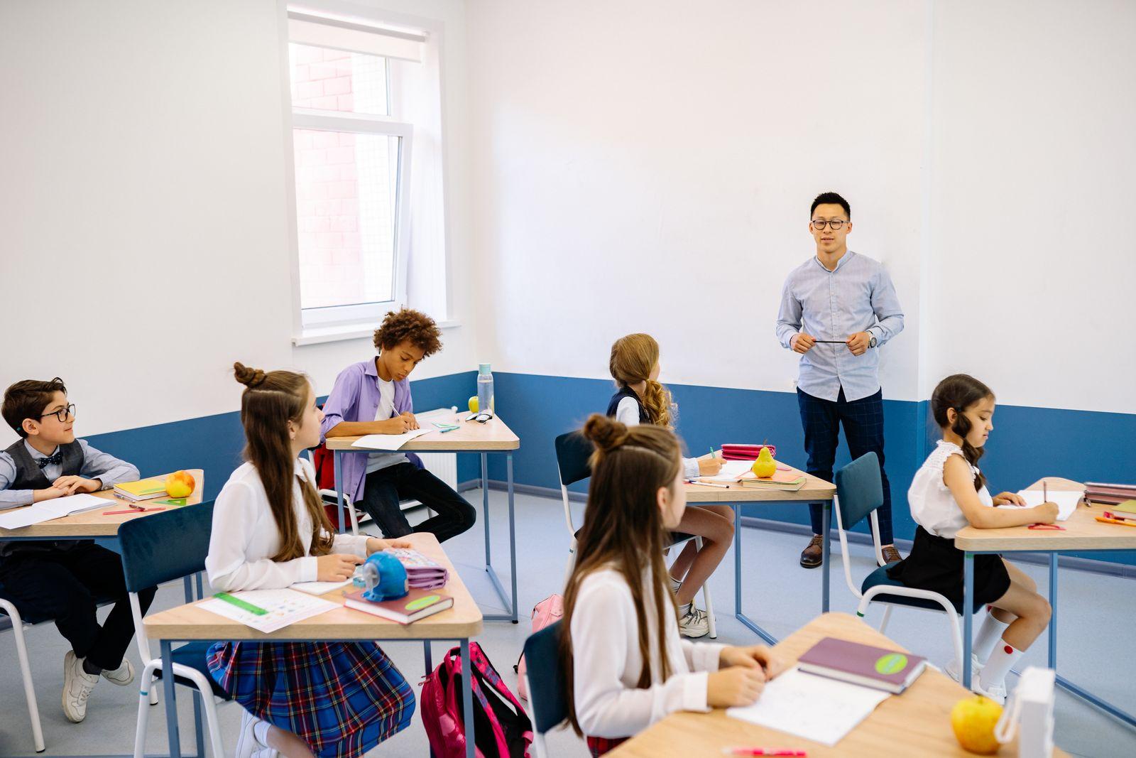 Teacher working with a diverse group of elementary students in a classroom